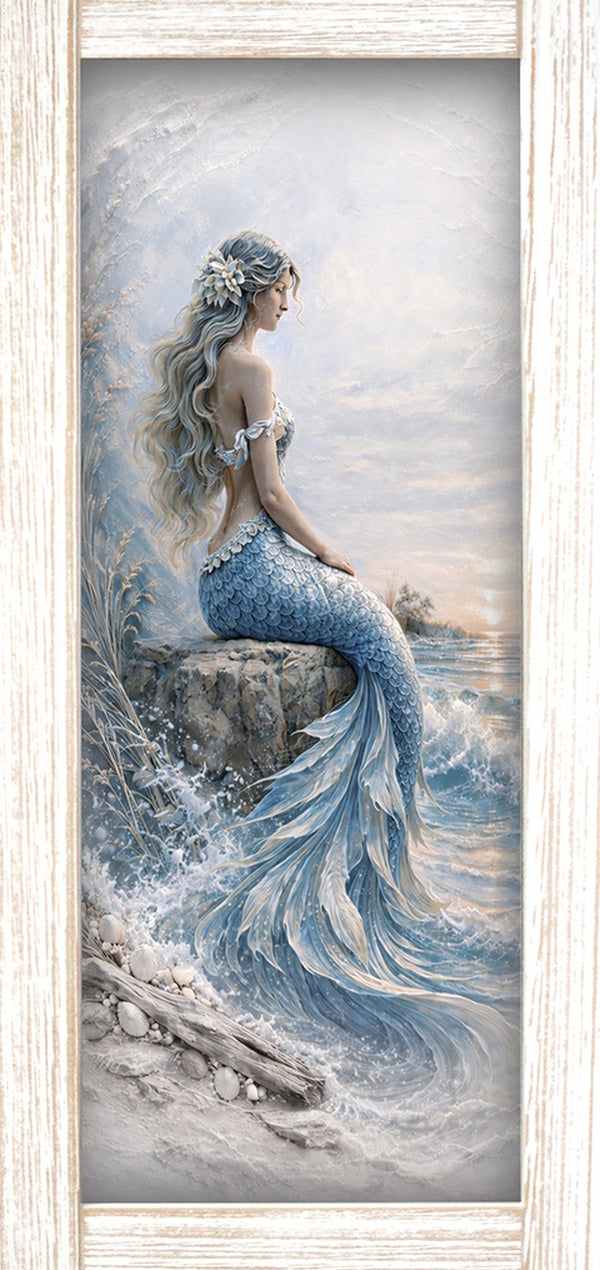 Print of a mermaid sitting on a rock by the sea in soft blues and white, shown in a light wood-tone frame.