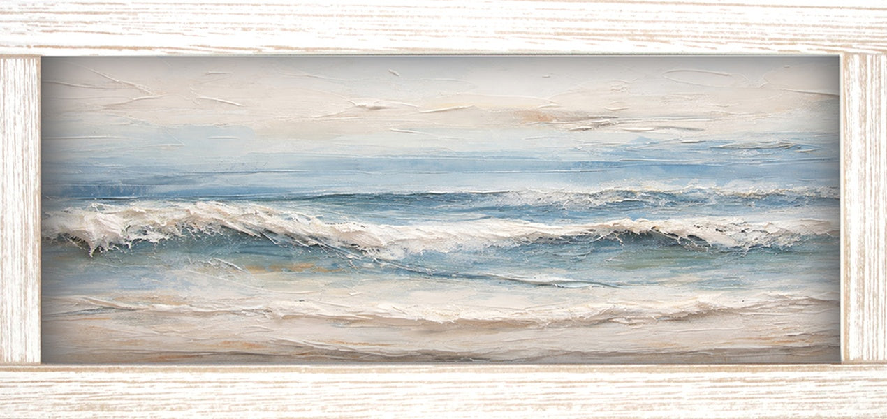 Print of gentle waves rolling onto a sandy beach in soft blues and beige, shown in a light wood-tone frame.